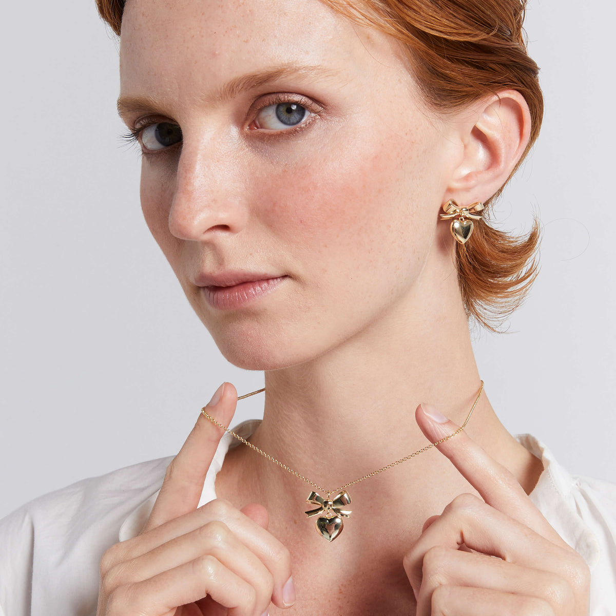 Model wearing Karen Walker Super Love Bow necklace and earrings