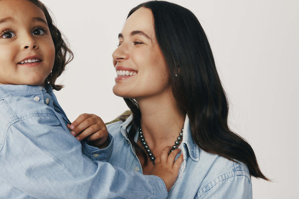 Mother and young son embracing and wearing matching denim shirts