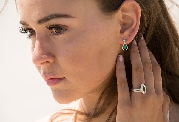 Model wearing emerald earrings and ring