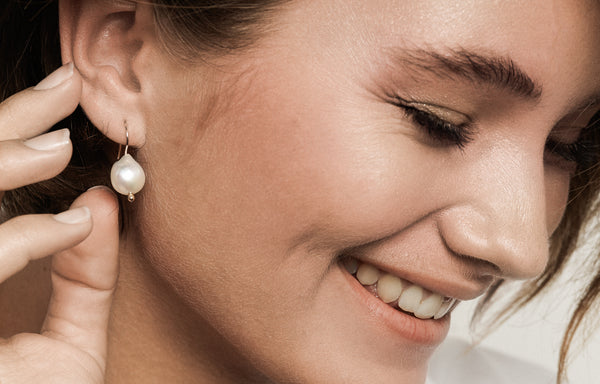 Model wearing pearl drop earrings