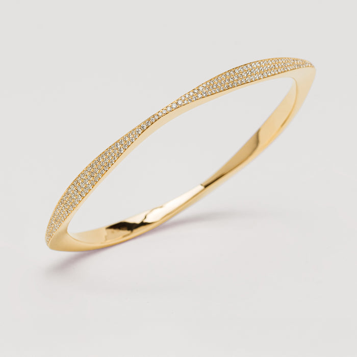 Yellow gold diamond Eos bangle on light grey background