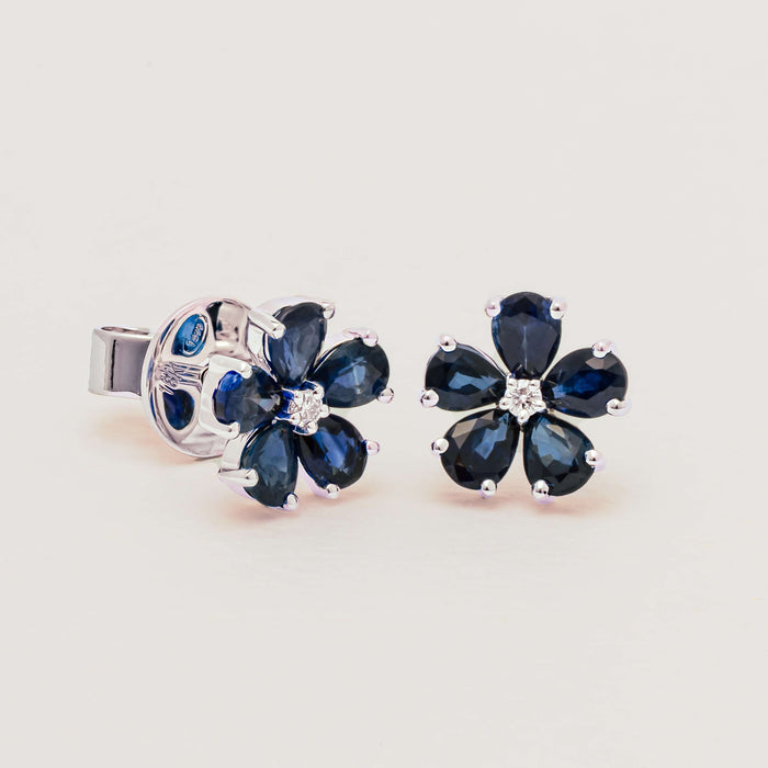 Sapphire flower stud earrings on neutral background
