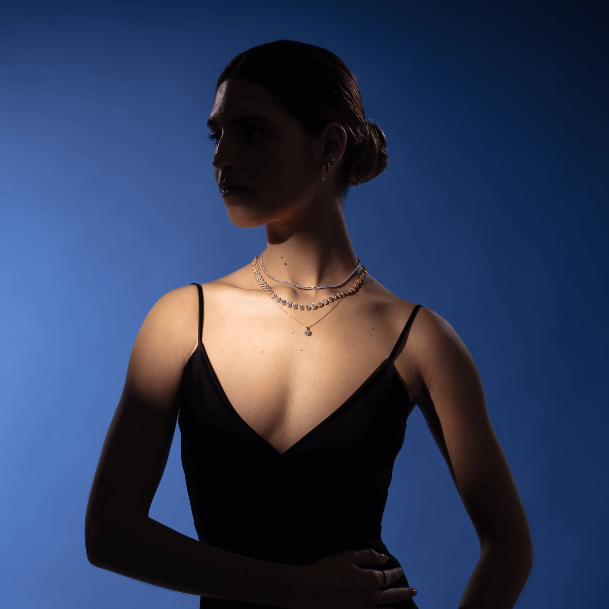 Silhouette of model with spotlight on diamond necklaces