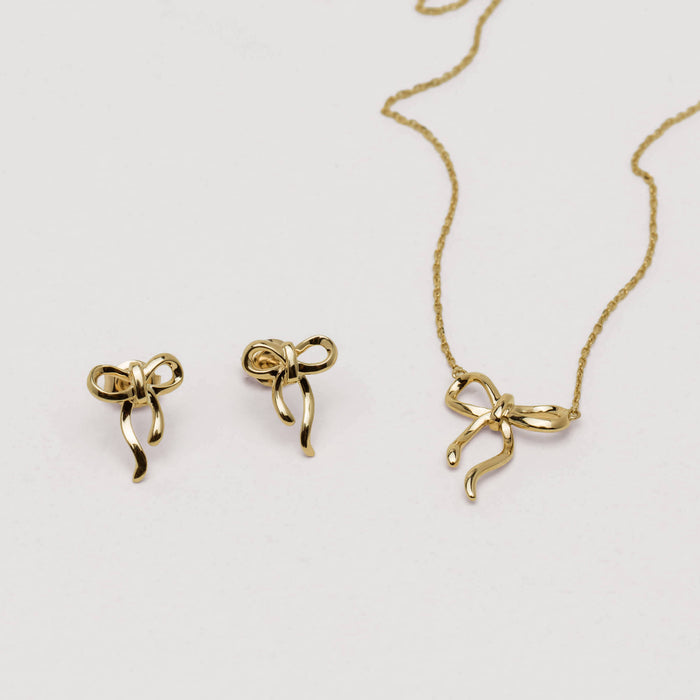Infinity Bow Necklace and Earrings on neutral background