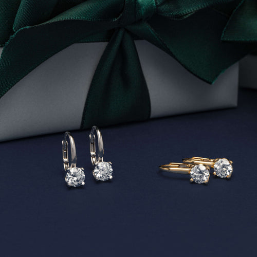 Diamond Blossom Earrings on navy background with wrapped Walker & Hall gift boxes