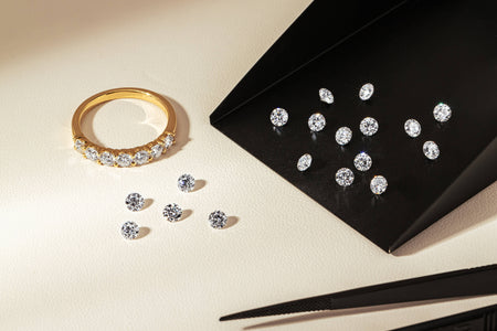 Panorama diamond band and loose round brilliant cut diamonds resting on neutral background