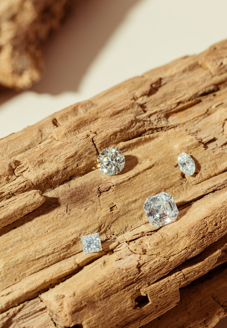 Loose reclaimed diamonds resting on driftwood