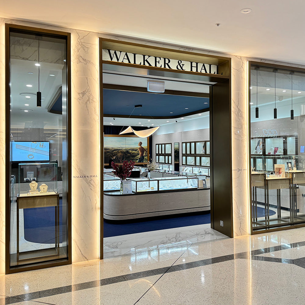 Storefront of Walker & Hall with glass display cases and interior lighting.