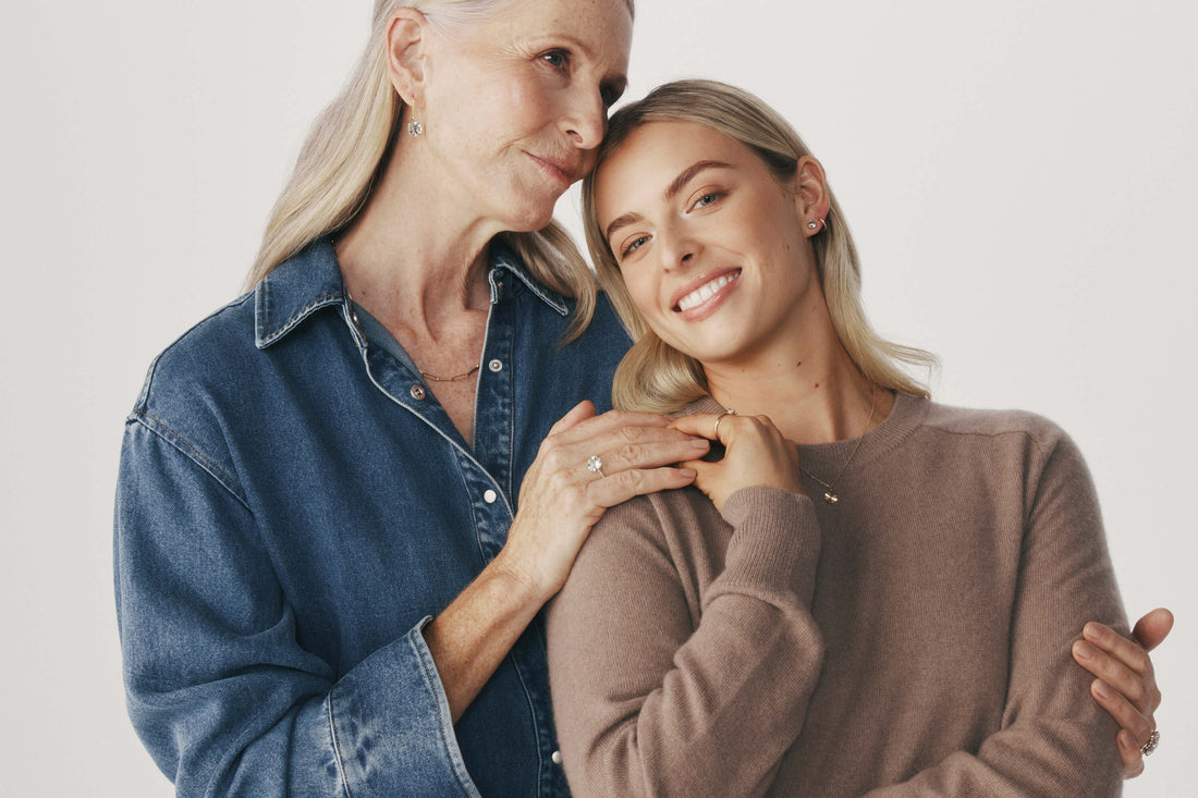 Grandmother and granddaughter embracing, wearing gold and natural gemstone jewellery