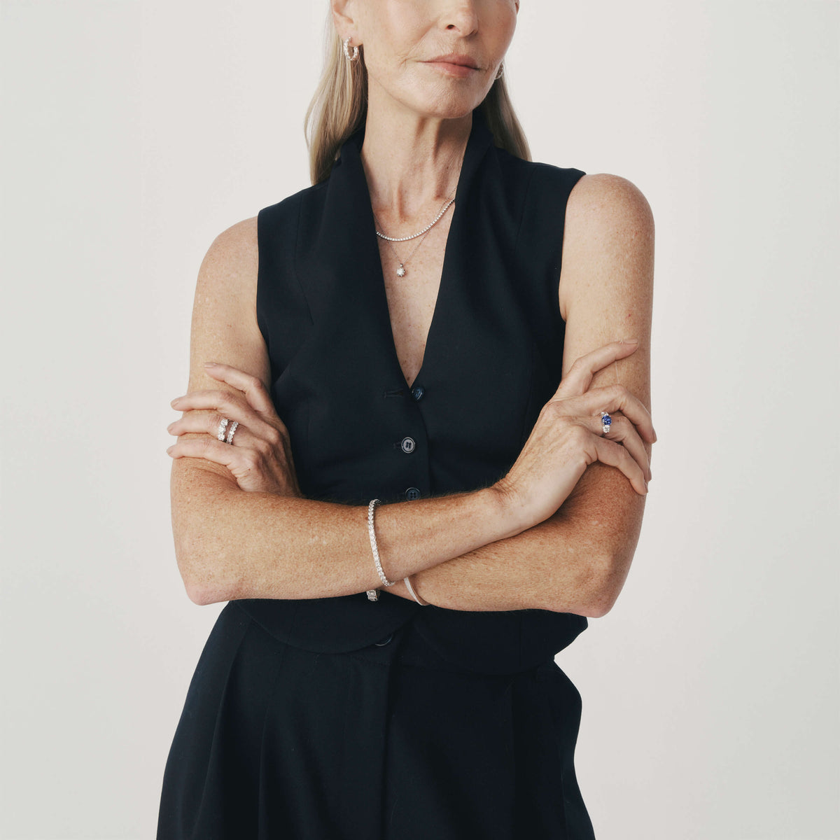 Model wearing diamond and sapphire rings and diamond bracelet, necklaces and earrings