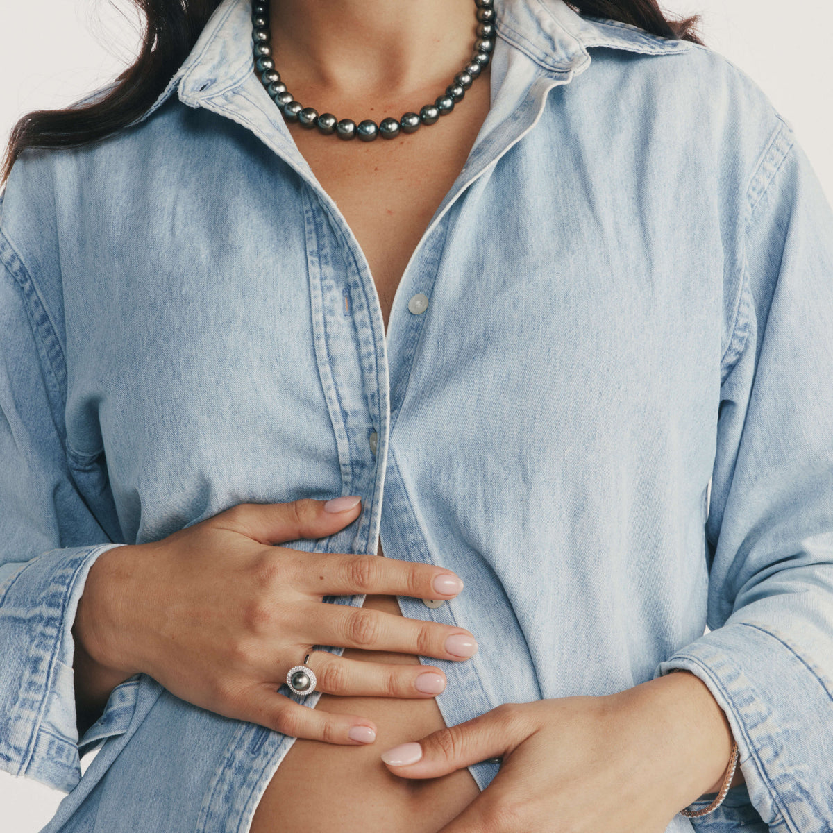 Close up of model wearing denim shirt and Tahitian Pearl Strand and Tahitian Pearl and Diamond Ring