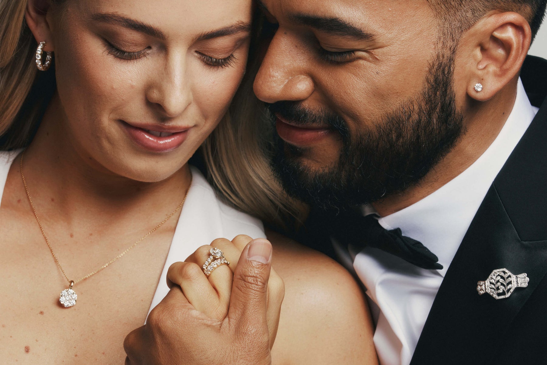Couple on their wedding day holding hands and wearing Natural Diamond Rings and Jewellery