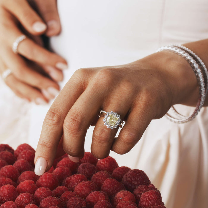Close up of a hand wearing yellow diamond engagement ring.