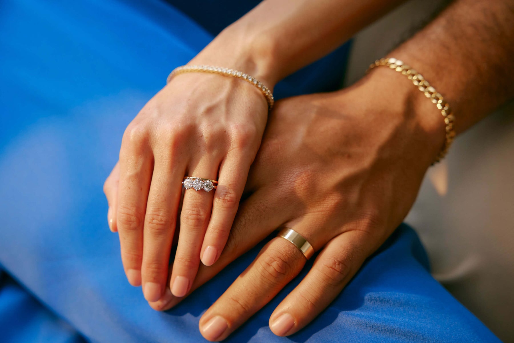 Couple holding hands wearing engagement and wedding rings