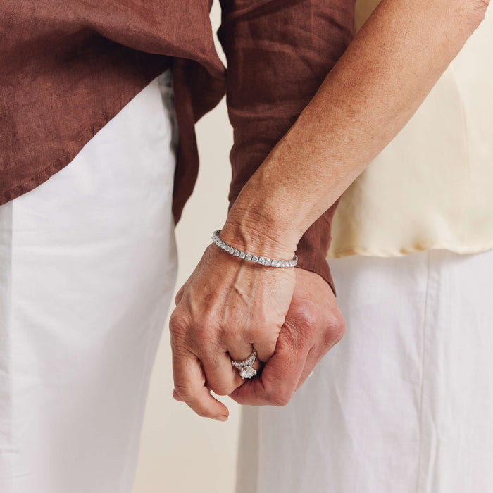 Couple holding hands, model wearing diamond Jubilee Bracelet and diamond wedding and engagement rings